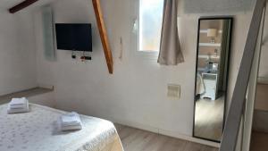 biały pokój z łóżkiem i telewizorem na ścianie w obiekcie Tuscany Dreaming we Florencji