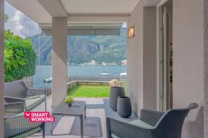 balcone con sedie e vista sull'acqua di Ninfea Apartments by Wonderful Italy a Lezzeno