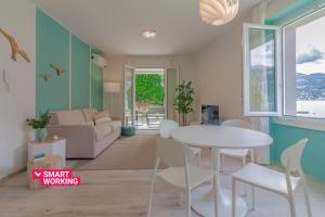 un soggiorno con tavolo e sedie bianchi di Ninfea Apartments by Wonderful Italy a Lezzeno
