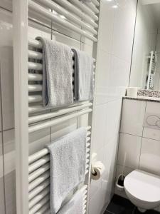 a bathroom with white towels and a toilet at TM Hotel Westfalen in Lünen
