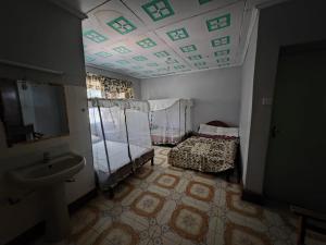 a room with a bathroom with a sink and a room with a bed at Mara bush house in Sekenani