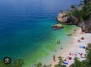 a group of people on a beach in the water at P&K in Rijeka