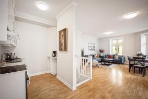 a kitchen and living room with white walls and wooden floors at Rosen Apartment in Bergen