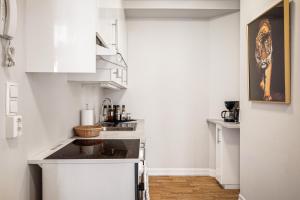a kitchen with white cabinets and a stove top oven at Rosen Apartment in Bergen