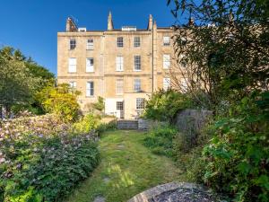 an old building in the middle of a garden at Pass the Keys Stunning garden flat with parking in Bath