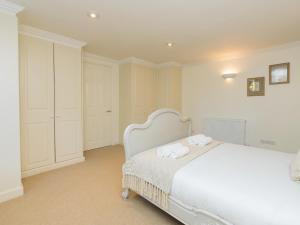 a bedroom with a white bed with towels on it at Pass the Keys Stunning garden flat with parking in Bath