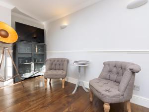 a living room with two chairs and a tv at Pass the Keys Stunning garden flat with parking in Bath