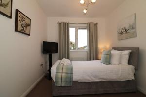 a bedroom with a bed and a window at Signature - Angus House Glasgow in Glasgow