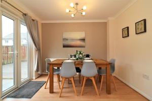 a dining room with a wooden table and chairs at Signature - Angus House Glasgow in Glasgow