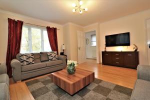a living room with a couch and a tv at Signature - Angus House Glasgow in Glasgow