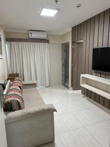 sala de estar con sofá y TV de pantalla plana en Piazza Diroma - Com acesso Acqua park CN-GO en Caldas Novas