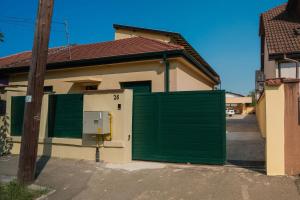 a green gate in front of a house at REZIDENTA OBLIGADO in Timişoara