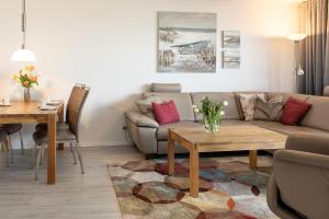 ein Wohnzimmer mit einem Sofa und einem Tisch in der Unterkunft Ostseeresidenz App 22 in Heiligenhafen