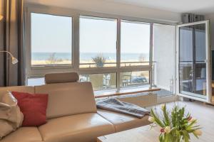 ein Wohnzimmer mit einem Sofa und Meerblick in der Unterkunft Ostseeresidenz App 22 in Heiligenhafen