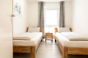 2 Einzelbetten in einem Zimmer mit Fenster in der Unterkunft Ostseeresidenz App 22 in Heiligenhafen
