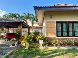 a house with a car parked in front of it at Malinee Villa Phuket in Bang Tao Beach