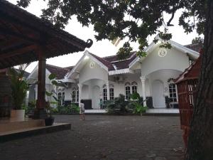 a child walks in front of a white building at HASTOSTAY @suryodiningratan in Timuran