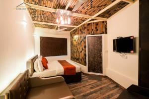 1 dormitorio con cama, sofá y TV en Comfort Inn Silver Arch Hotel, Mussoorie, en Mussoorie