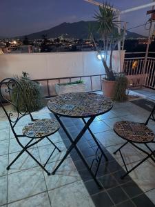una mesa y 2 sillas sentadas en un balcón en B&b L’Attico e la Ballata, en Brusciano