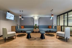 a waiting room with two blue couches and chairs at Thirtynine Urban Stay in Thessaloniki