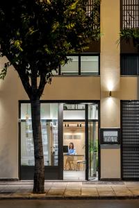 a woman sits in the doorway of a building at Thirtynine Urban Stay in Thessaloniki