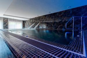 una piscina con cascata in un edificio di Diamond Panzió a Hajdúszoboszló