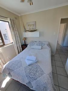 a bedroom with a bed with two towels on it at Serengeti Heide Self Catering Flats in Cape Town +8 photos