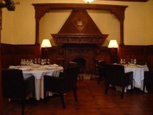 une salle à manger avec des tables, des chaises et une cheminée dans l'établissement Hotel Rural OLIVENZA PALACIO, à Olivenza