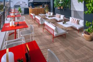 a restaurant with red tables and white chairs at Hotel SERHS Rivoli Rambla in Barcelona