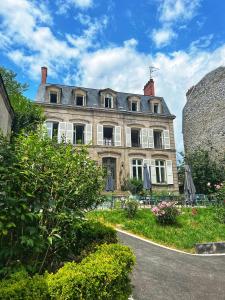 a large stone house with a garden in front of it at La maison de famille Limoges in Limoges