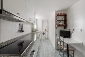 a white kitchen with a sink and a counter at Latido del Puerto in Puerto de Sagunto