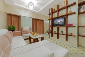 a living room with a couch and a tv at Palestine Hotel Makkah in Makkah