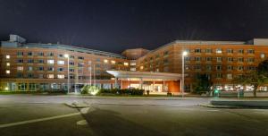 an empty parking lot in front of a building at night at PLAZA Premium Wien in Vienna