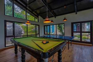 a pool table in a room with windows at Seed At Queens Meadows, Ranikhet in Rānīkhet