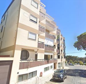 a building with a car parked in front of it at Estoril Casino 3 Bedrooms With Pool in Estoril
