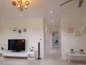 a living room with a flat screen tv on a wall at Waterfront Sunset Apartment in Fantasy Island Nadi in Nadi