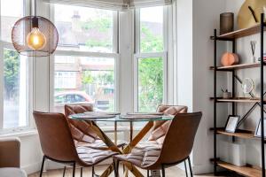 a dining room with a table and chairs and a window at Fantastic 2BR flat wgarden, West Norwood in West Dulwich