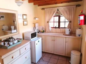 a kitchen with a white refrigerator and a window at Peebles Cottage in Clarens