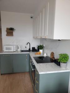 a kitchen with white cabinets and a counter top at Komfortowy apartament z balkonem i parkingiem in Wrocław