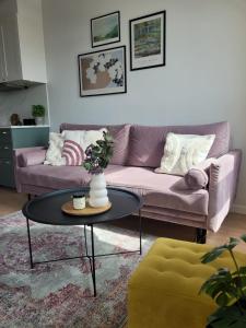 a living room with a purple couch and a table at Komfortowy apartament z balkonem i parkingiem in Wrocław
