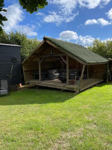 a wooden gazebo with a roof on the grass at Oak Tree Lodge: Unique 2 level Shepherd's Hut: Dartmouth in Dartmouth