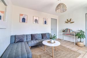 - un salon avec un canapé bleu et une table dans l'établissement LE TOLOSANA - Appartement 4 personnes - Centre WiFi Cosy, à Saint-Gilles