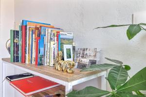 une étagère avec des livres et des sculptures d'or dans l'établissement LE TOLOSANA - Appartement 4 personnes - Centre WiFi Cosy, à Saint-Gilles