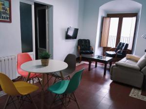 a living room with a table and chairs and a couch at Apto La Almena 2 junto a Plaza Mayor,2 habitaciones,parking gratuito in Cáceres