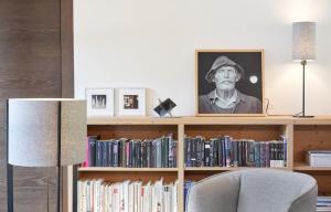a book shelf with a portrait of a man on it at Saleghes Dolomites Residence in Selva di Val Gardena