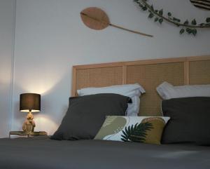 1 dormitorio con 1 cama con cabecero y lámpara en Jungle suite - moderne et spacieux, en Annecy