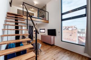 a room with a staircase and a large window at VV hotel & apartments in Brno