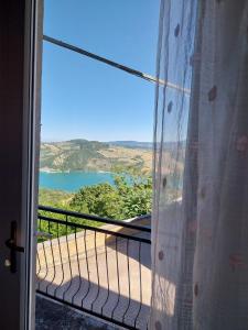 a door to a balcony with a view of a lake at La Casa sul lago in Fara San Martino