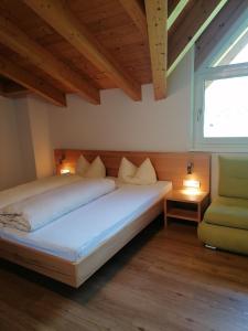 ペットイ・アム・アールベルクにあるApart Stella Alpinaのベッドルーム1室(ベッド1台、窓、椅子付)