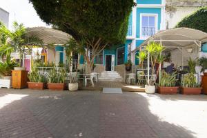 un patio con mesas y sillas y un edificio azul en Hotel Santa Maria en Praia